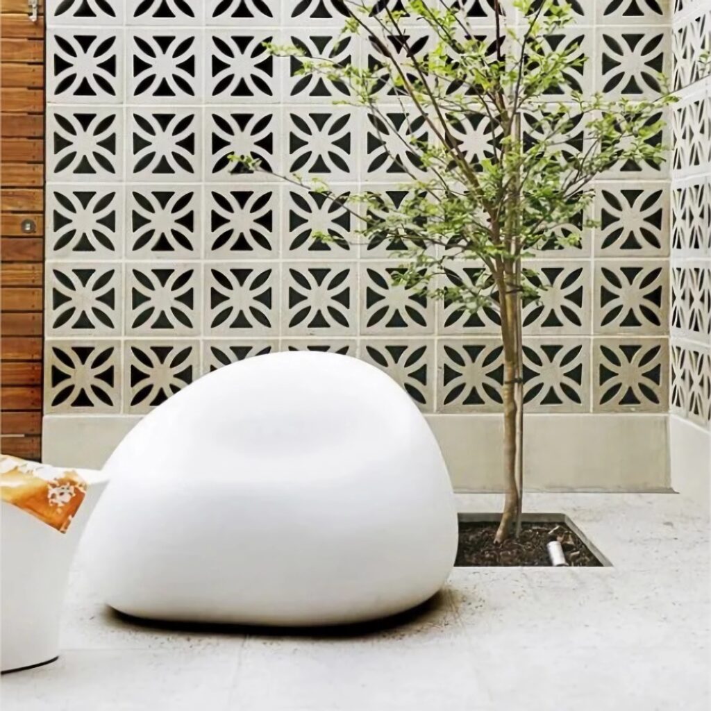 Ambiente moderno com cobogós e pisos cimentícios, mostrando a integração entre luz natural, textura e design clean.