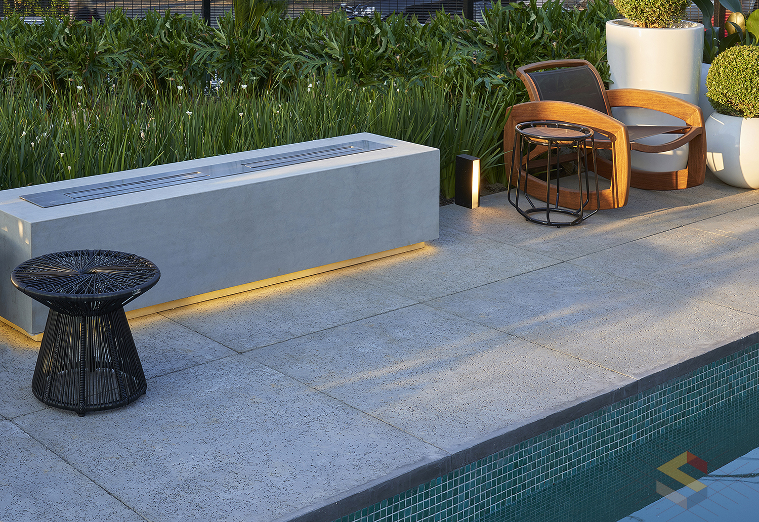 Piso cimentício Vaticano cor Grafite da Strutturare aplicado em área externa com piscina, garantindo conforto térmico e sofisticação.